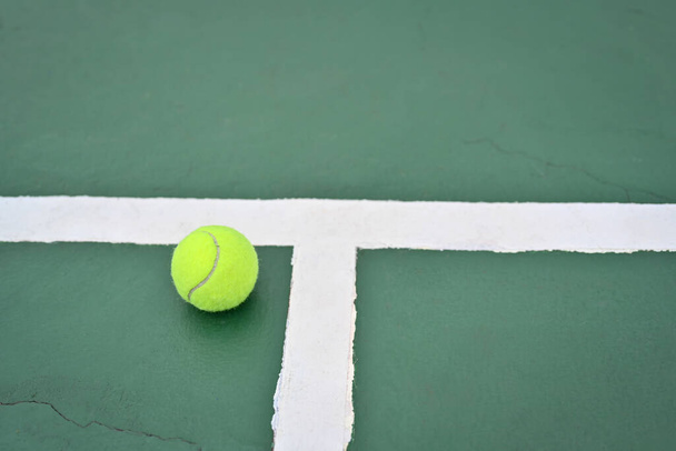 Tennis bal op groene buitenbaan met kopieerruimte aan de rechterkant. Tennisspel, outdoor sport en welzijn concept. - Foto, afbeelding