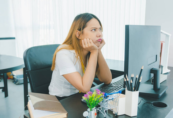 Trabalhadora de escritório do sexo feminino é estressada e pensativa em encontrar problemas durante o trabalho. - Foto, Imagem