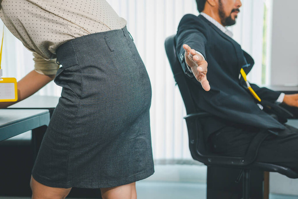 boss or supervisor is touching the buttocks of a female employee with his hand. This made the female employees resist because they were uncomfortable and afraid of being sexually harassed. There is sexual harassment in the workplace. - Фото, зображення
