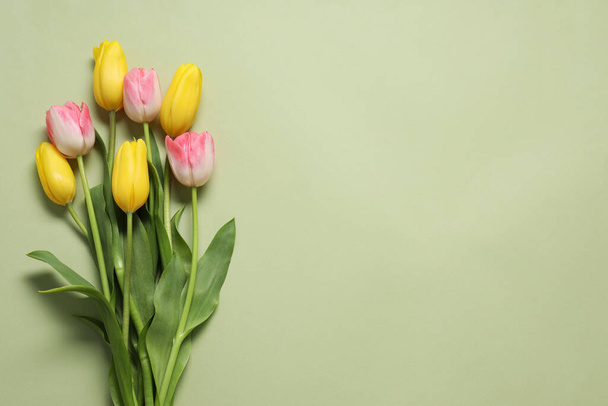 Beautiful colorful tulip flowers on pale olive background, flat lay. Space for text - Φωτογραφία, εικόνα
