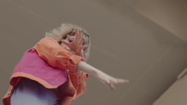 Χαμηλή γωνία slowmo δροσερό κορίτσι σε ροζ y2k στολή χορό Vogue στην κάμερα στο βιομηχανικό περιβάλλον - Πλάνα, βίντεο