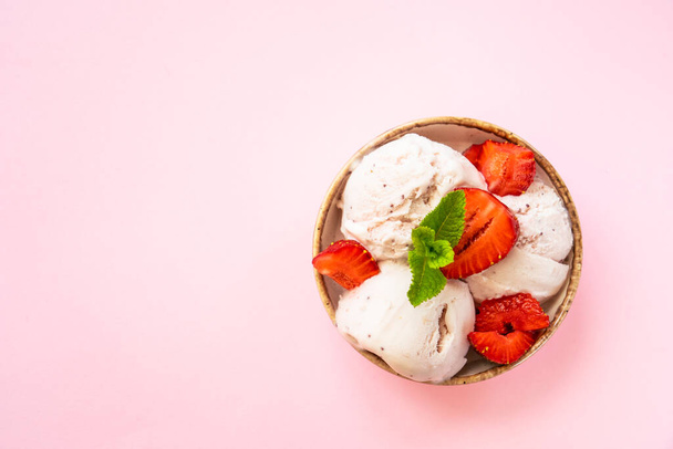 Homemade ice cream with fresh strawberries on pink background. Flat lay with copy space. - Photo, Image