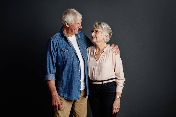 Lost in love. Studio shot of an affectionate senior couple posing against a grey background - Fotó, kép