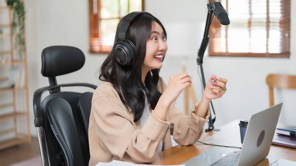 Žena podcasteru mluví o vzrušených novinkách na mikrofonu k nahrávání podcastu v broadcast studiu. - Fotografie, Obrázek