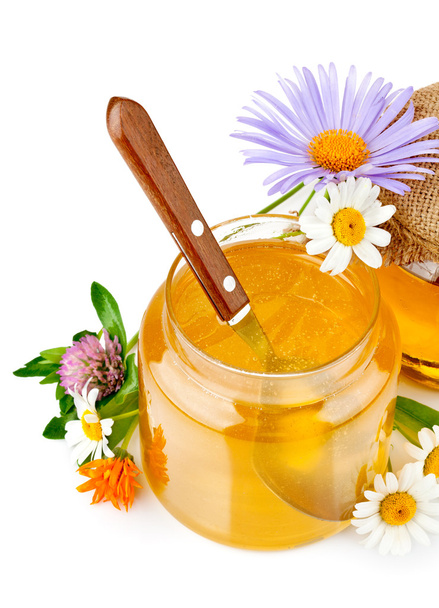 Sweet honey in glass jars with spoon and flowers - Foto, immagini