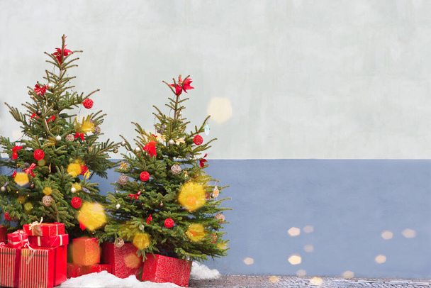 arbres de Noël avec bokeh doré et cadeaux rouges. fond avec arbre de Noël d'hiver bleui avec neige le jour - Photo, image