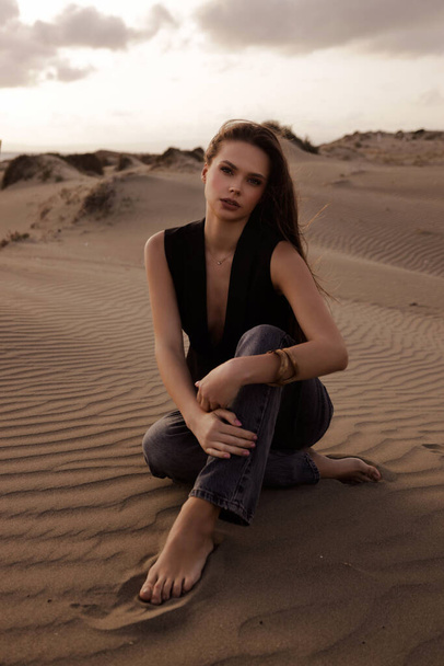 fashion outdoor photo of beautiful sexy woman with dark hair in casual clothes posing in the place in Cyprus, that looks like a desert - Zdjęcie, obraz