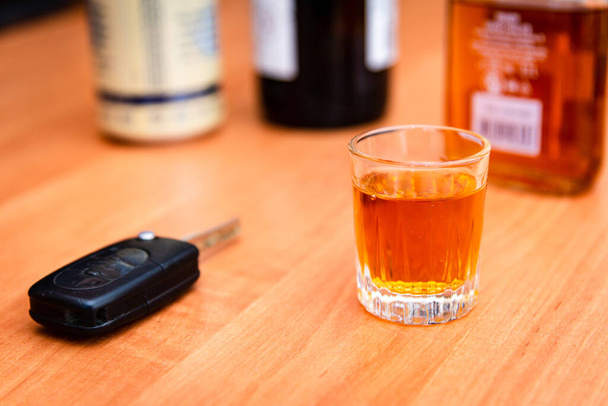 Bebida y llaves automáticas.Un vaso de whisky y llaves del coche en la mesa.Para conducir o no conducir, concepto de adicción al alcohol. - Foto, imagen
