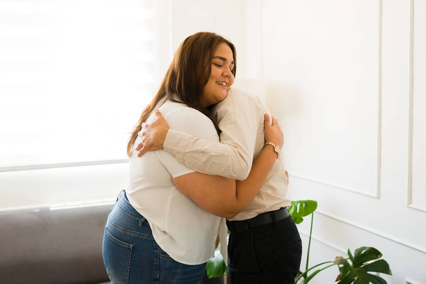 Happy latin woman smiling looking cheerful while hugging her psychologist feeling grateful with the therapy help with depression - Foto, imagen