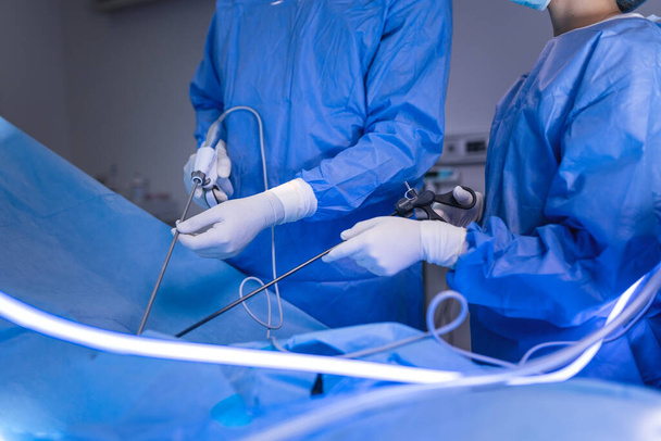 外科医は患者の腹部に楽器を持っています。手術室で腹腔鏡手術をしてる。最小侵襲手術. - 写真・画像