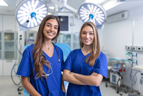 Fiatal női egészségügyi szakemberek állnak össze. az egészségvédelem fogalma. Az orvosok sikeres csapata a kamerába néz és mosolyog, miközben a kórházban áll. - Fotó, kép