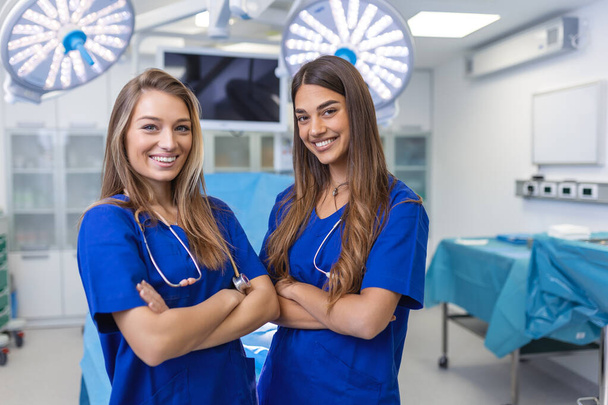 Fiatal női egészségügyi szakemberek állnak össze. az egészségvédelem fogalma. Az orvosok sikeres csapata a kamerába néz és mosolyog, miközben a kórházban áll. - Fotó, kép