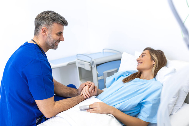 Healthcare concept of professional doctor consulting and comforting patient in hospital bed or counsel diagnosis health. Medical doctor or nurse holding patient's hands and comforting her - Photo, image
