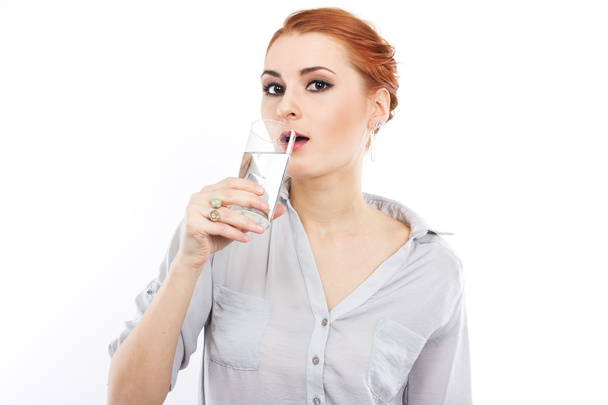 Happy young girl with a glass of water. A glass of water. Healthy life. Red-haired girl - Foto, imagen