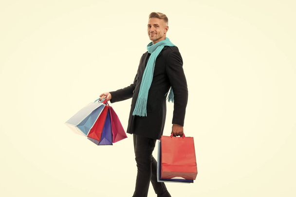 glad shopping man with purchase in studio. shopping man with purchase on background. photo of shopping man with purchase. shopping man with purchase isolated on white. - Foto, Bild