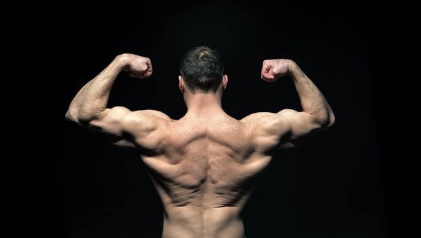 bodybuilder man muscular back isolated on black. bodybuilder man muscular back in studio. bodybuilder man muscular back on background. photo of bodybuilder man muscular back. - Zdjęcie, obraz