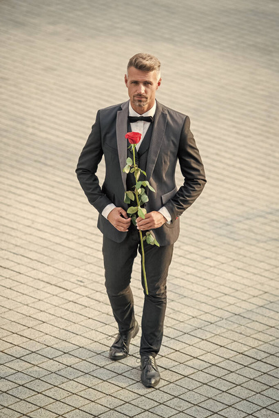 engagement date. tuxedo man celebrates engagement. man with rose gift for engagement. - Foto, Imagen