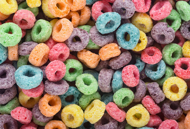 Deliciosos y nutritivos anillos de cereales de frutas como fondo, vista superior. Desayuno saludable. - Foto, imagen