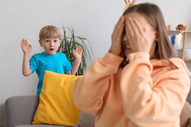 Little boy and nanny playing hide-and-seek at home - Photo, Image