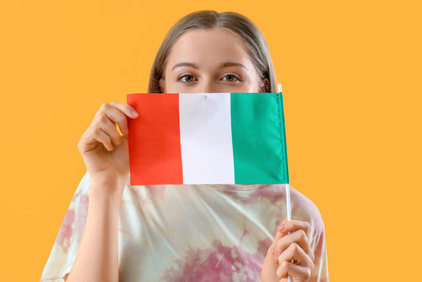 Pretty young woman with flag of Italy on yellow background - Valokuva, kuva