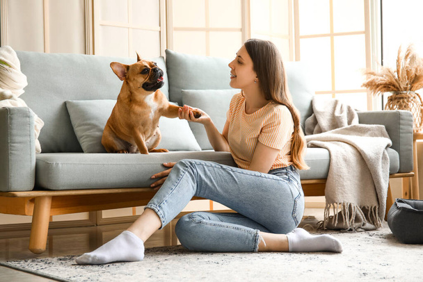 Young woman with cute French bulldog at home - Fotoğraf, Görsel