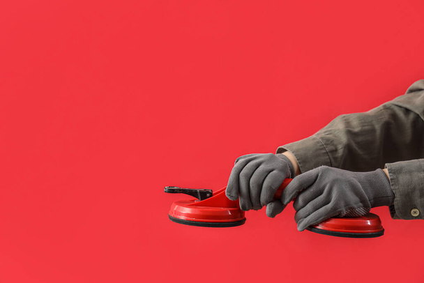 Female hands in gloves holding double vacuum suction cups on red background - Photo, Image