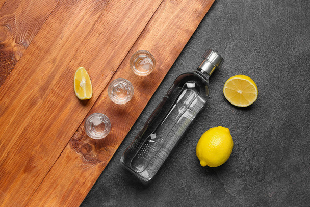 Botella y vasos de vodka con limón en la mesa - Foto, imagen