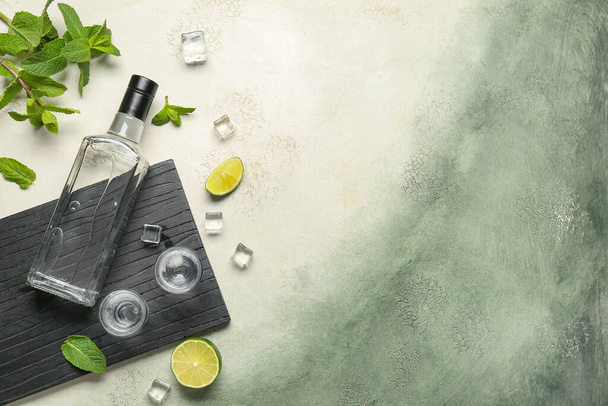 Flasche und Gläser Wodka mit Limette auf Grunge-Hintergrund - Foto, Bild