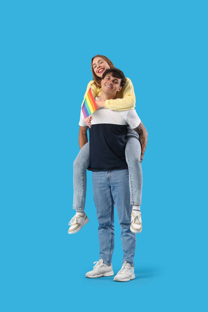 Young couple with LGBT flag on blue background - Valokuva, kuva