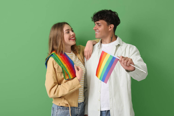 Casal jovem com bandeiras LGBT em fundo verde - Foto, Imagem