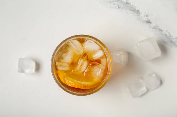 Glass of ice tea with orange on white background - Photo, Image