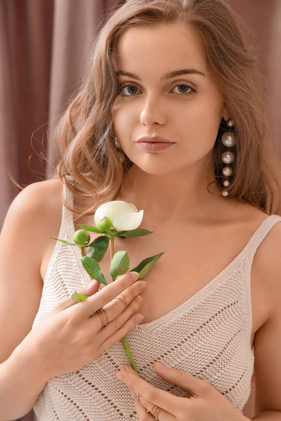 Beautiful young woman with peony flower, closeup - Photo, Image