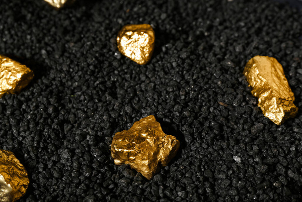pepitas de oro sobre carbón negro, primer plano - Foto, imagen
