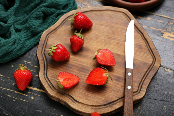 Tafel mit frischen Erdbeeren auf schwarzem Holzhintergrund - Foto, Bild