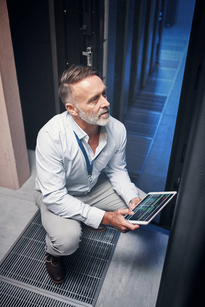 Получите лучшую скорость интернета с помощью этого ИТ-гуру. зрелый человек, использующий цифровой планшет во время работы в серверной комнате - Фото, изображение