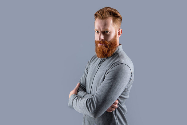 Irish man half turn keeping arms crossed. Confident man with beard and mustache. Bearded man studio isolated on grey, copy space. - Фото, изображение