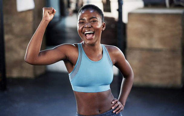 Portrait, fitness ou femme noire heureuse fléchissant avec des objectifs musculaires ou corporels biceps forts lors de l'entraînement. Exercice, bras puissants ou athlète sportive africaine en bonne santé excitée par les résultats au gymnase. - Photo, image