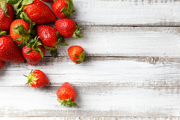 Μούρα από μεγάλες ώριμες φρέσκες βιολογικές φράουλες σε ξύλινο φόντο close-up, top view, με χώρο για κείμενο. - Φωτογραφία, εικόνα