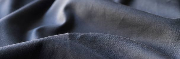 Top view of black wavy fabric textured background, cloth texture backdrop. Dark cloth for sewing. Beautiful crumpled pattern - Zdjęcie, obraz