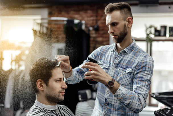 Professional barber styling hair of his client - Fotoğraf, Görsel