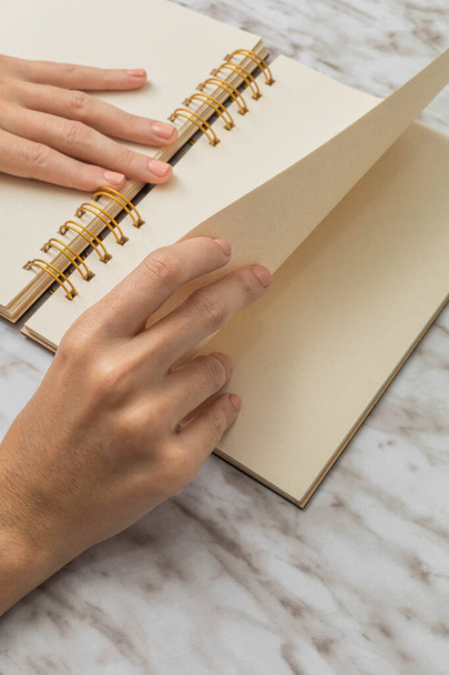 detail of the hands of a person passing the blank pages of a notebook, stationery object, material for study and learning, wallpaper in studio - Photo, Image