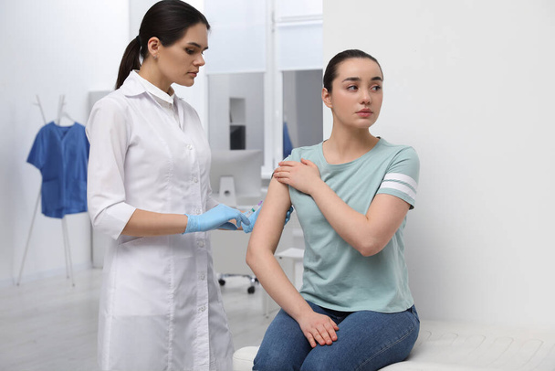 Doctor giving hepatitis vaccine to patient in clinic - Fotoğraf, Görsel