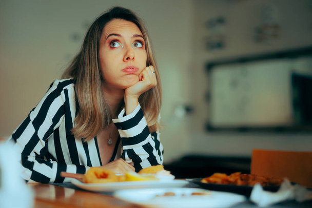 Bored Woman Sitting in a Restaurant Not Eating her Food - Photo, image