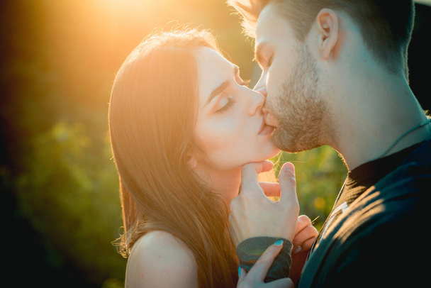 Kadın öpücüğü veren bir adam. Gün batımında aşk hikayesi. Sarılmak ve öpüşmek. - Fotoğraf, Görsel