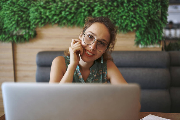 Мне нравится гибкость быть фрилансером. молодая женщина использует ноутбук во время работы в кафе - Фото, изображение