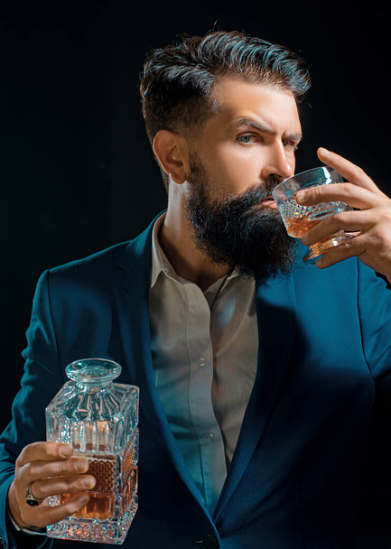 Sipping whiskey. Man Bartender holding glass of whisky. Bearded handsome man holding glass of whiskey. Sipping finest whiskey - Фото, зображення