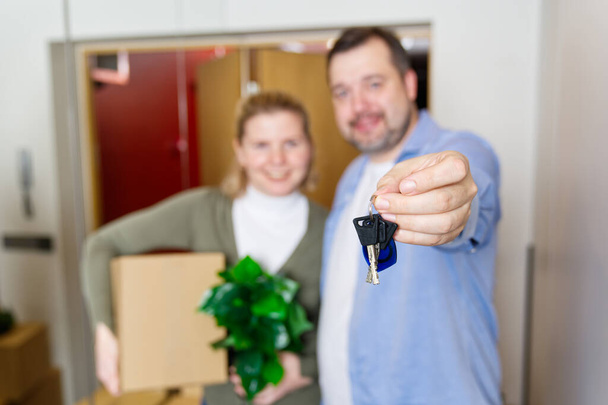 Couple showing keys to new apartment. real estate mortgage, loan concept. moving in new house. Young smiling couple holding their new house keys. first own apartment or house. - Fotoğraf, Görsel