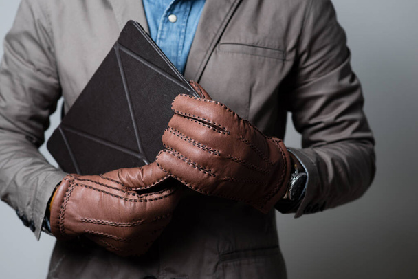 A man wearing the brown leather gloves in winter. - Foto, Imagem