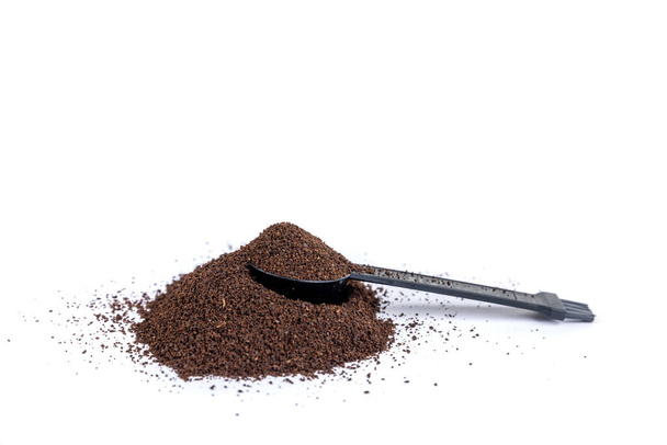Serving measuring scoop full of coffee grounds in a hill of coffee - Photo, Image