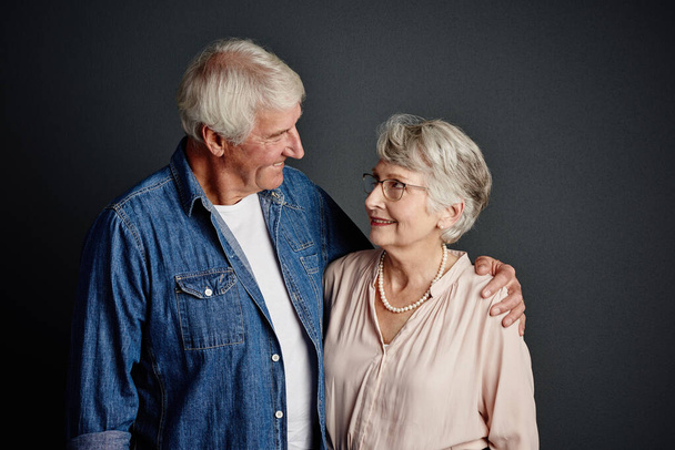 Завжди щасливий разом. Студійний знімок лагідної старшої пари позує на сірому фоні
 - Фото, зображення